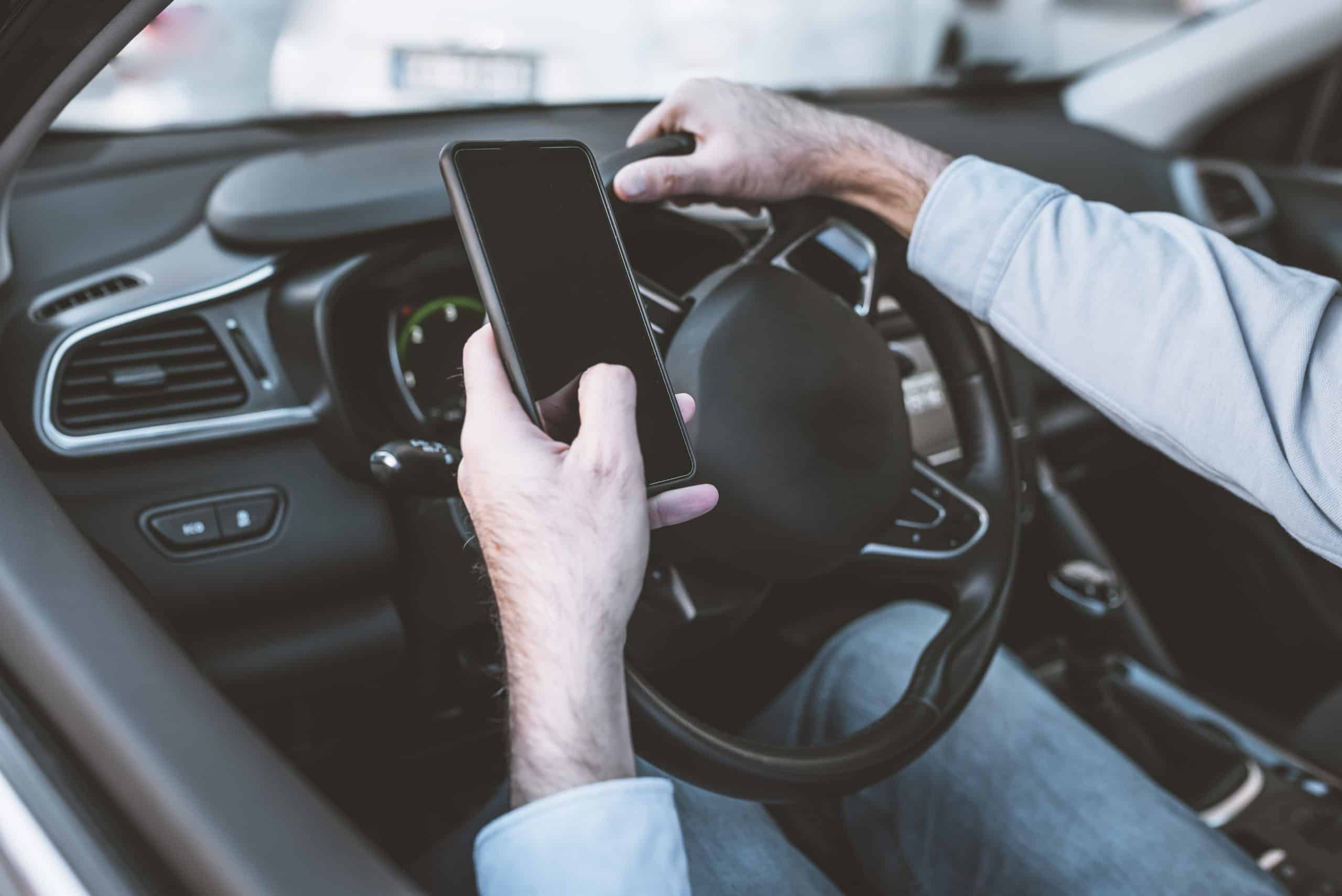 man driving with phone before needing a distracted driving accident lawyer