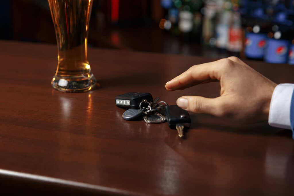 Man reaching for his keys at the bar, signifying what to do after beng hit by a drunk driver