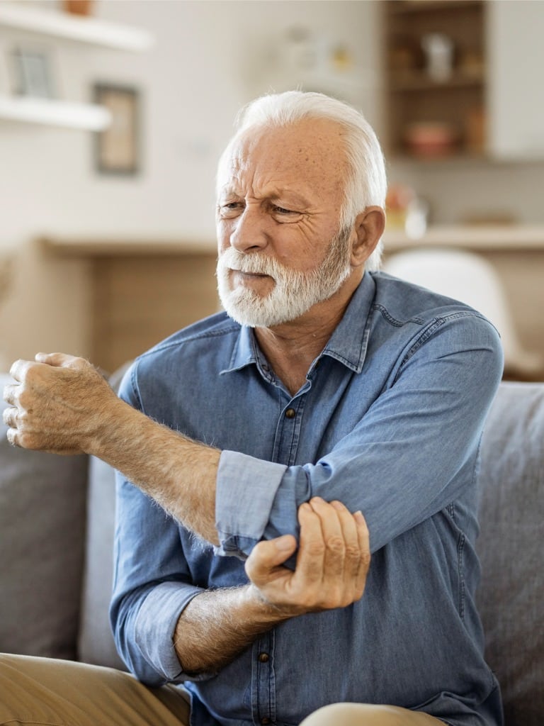 Older man holding his elbow in pain while needing a disability lawyer in Spartanburg, SC
